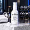 TheLooksMaxxing Anti-Aging Moisturizer bottle on a marble plinth in a dark gym