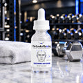 TheLooksMaxxing Hyaluronic Acid Serum dropper bottle on a marble plinth in a dark gym